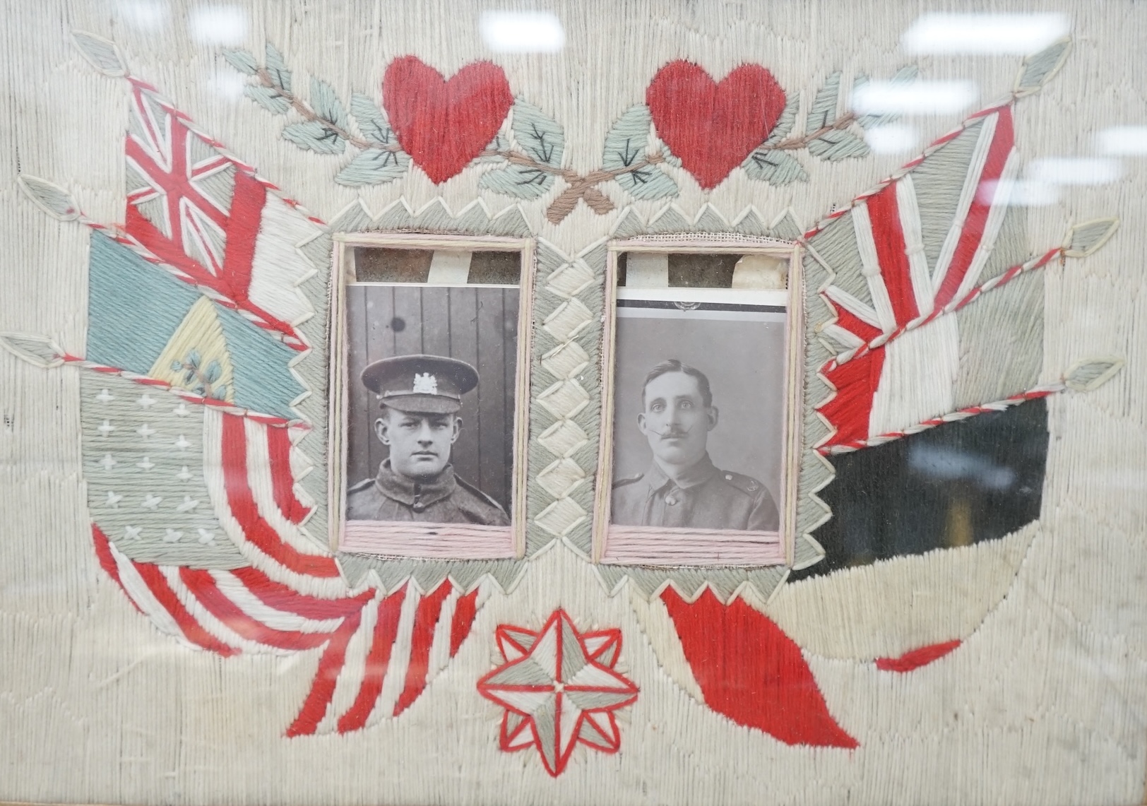 Two early 20th century woolwork panels housing black and white photographs to include soldiers in military dress, maple framed, 42 x 52cm. Condition - fair